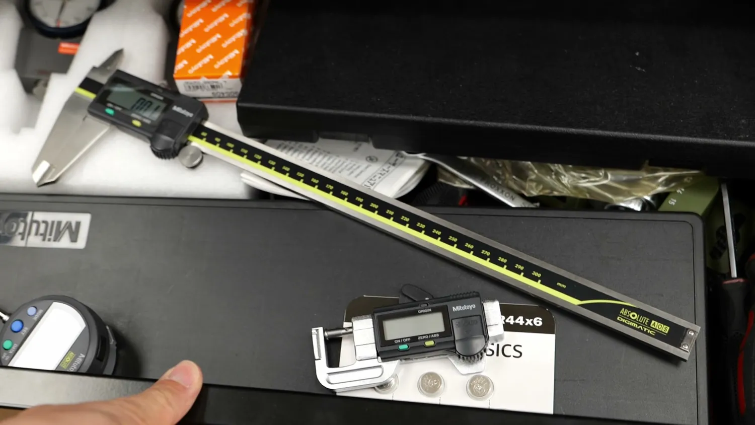 Messy drawer with Mitutoyo precision tools piled up