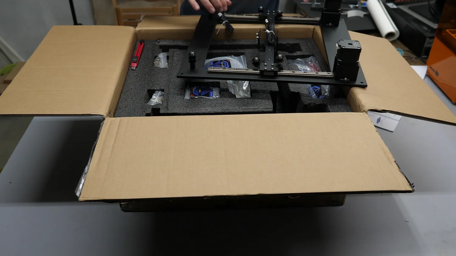 The kit as delivered, the top plate with its linear rails and belts lifted out of the foam-packed box