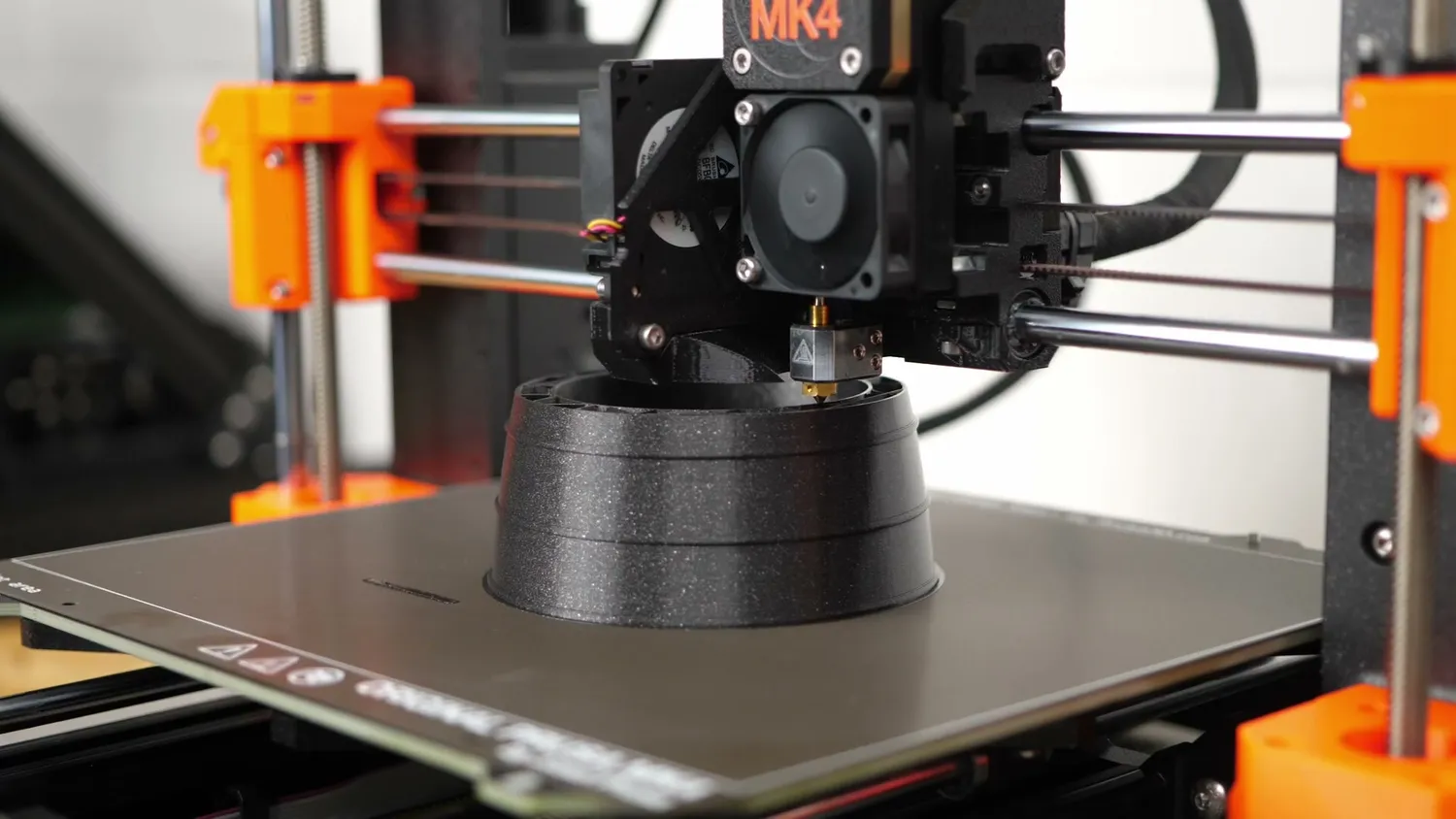 Prusa MK4 printing a black rocket engine model